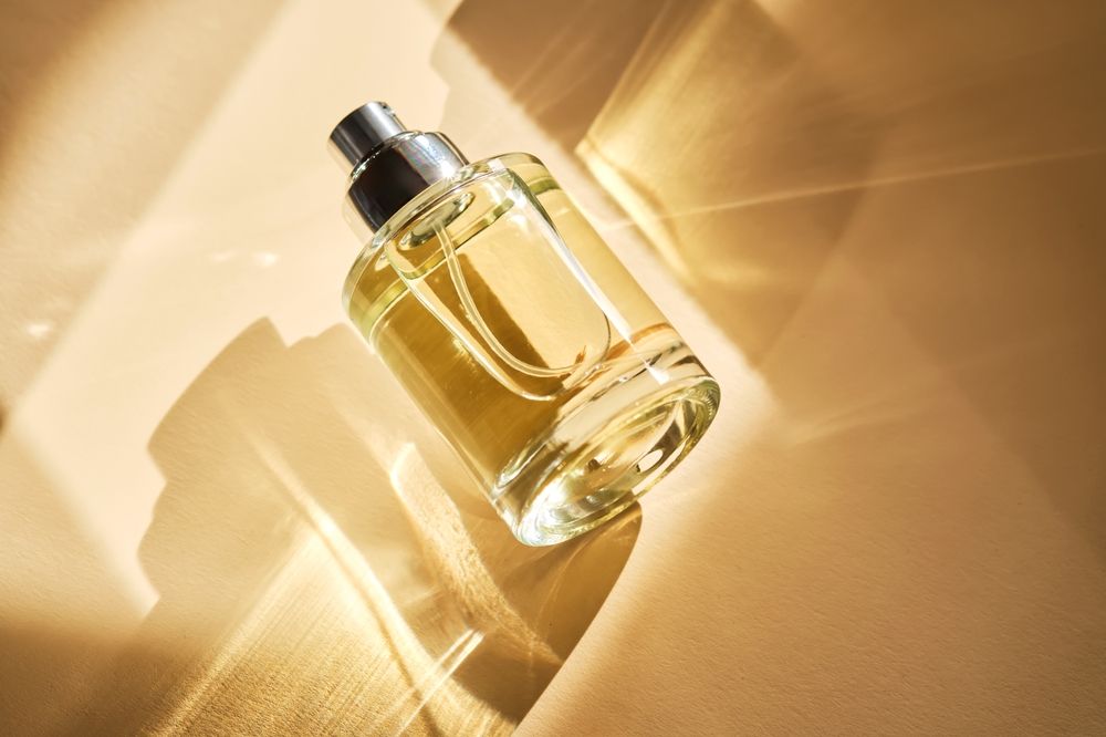 A fragrance-style round with a crimp sprayer over a beige background.